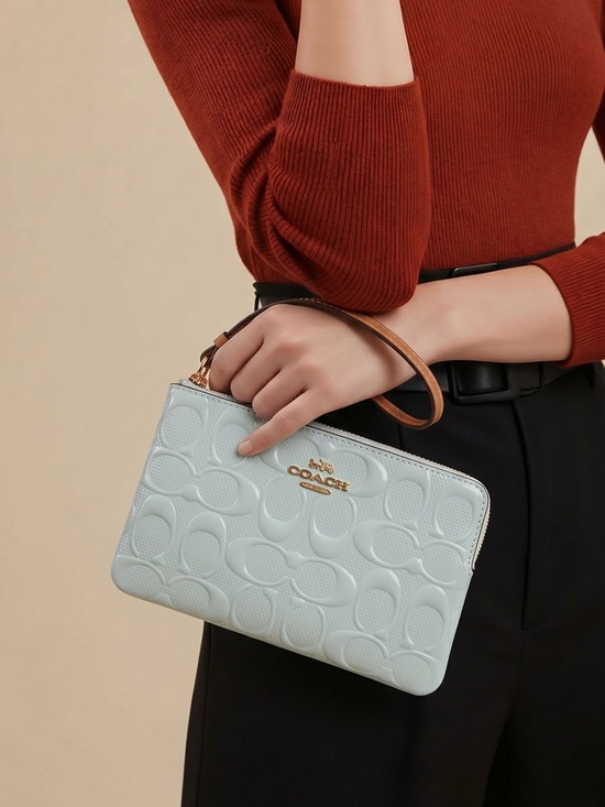 Coach Handbags - COACH Light Blue Embossed Signature Wristlet with Tan Strap
